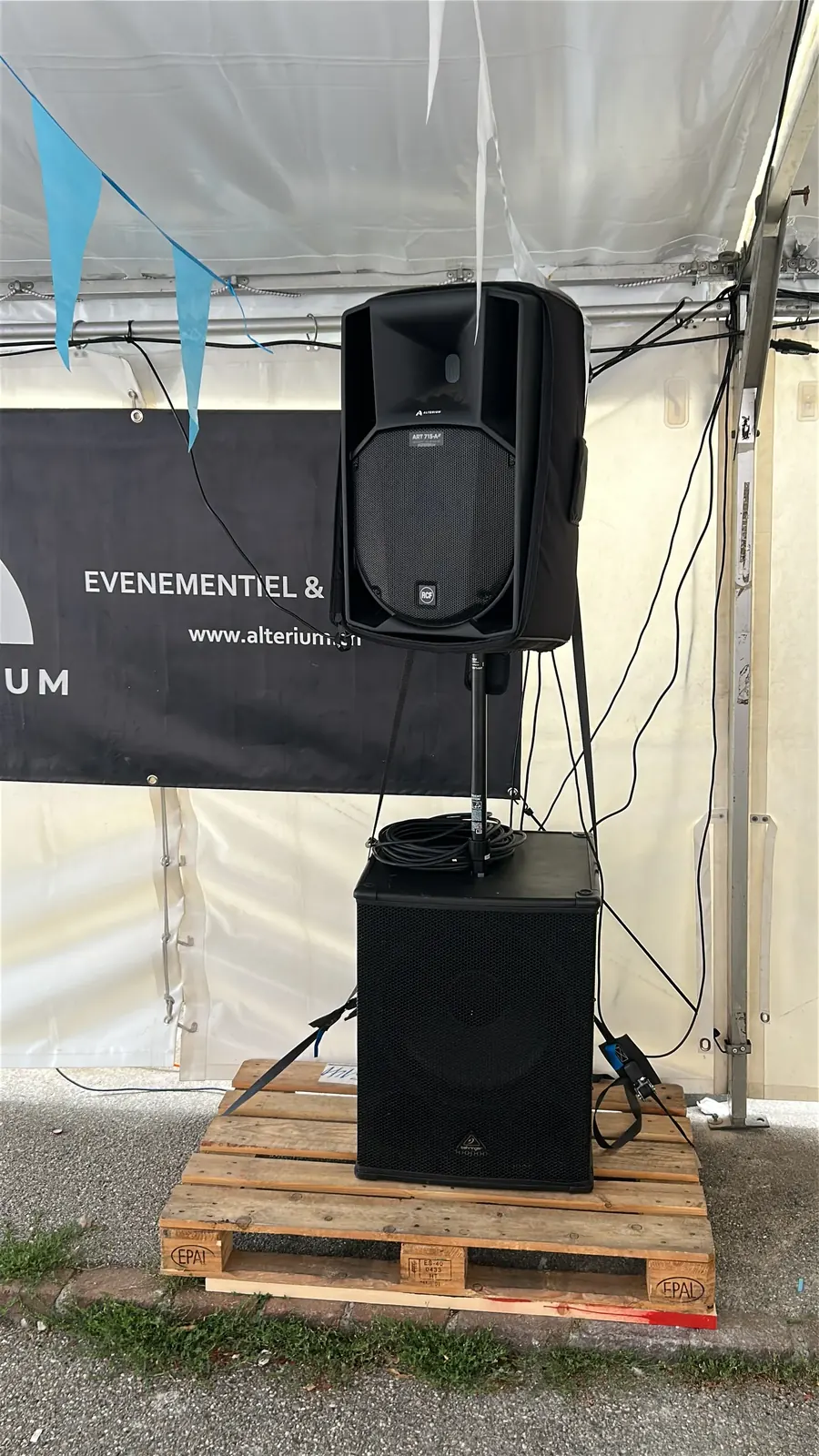 Enceinte montée sur pied au-dessus d'un caisson de basse, devant la bâche Alterium, lors de l'édition 2025